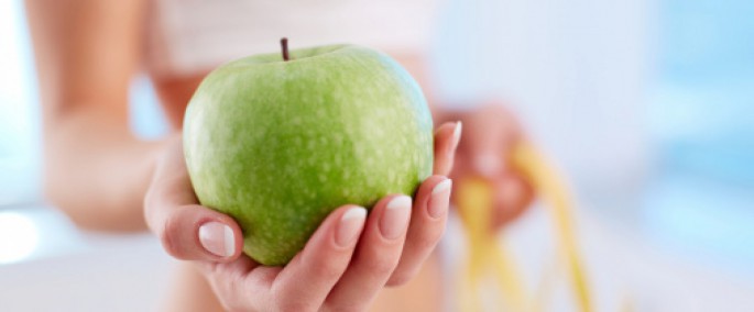 mano mostrando manzana verde